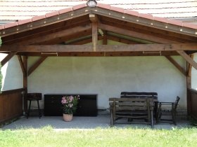 Überdachte Terrasse mit Holzmöbeln und Blumentopf, © Familie Steindl